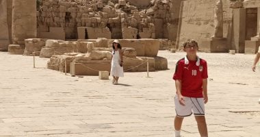 مرتديا تيشيرت محمد صلاح فى المنتخب.. طفل إنجليزي وأسرته يزورون معابد الكرنك