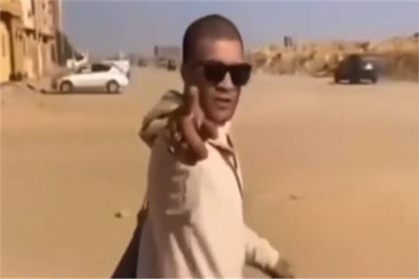 الأمن يفحص فيديو لشاب يقفز من أعلى باب عقار بحقيبة في يده