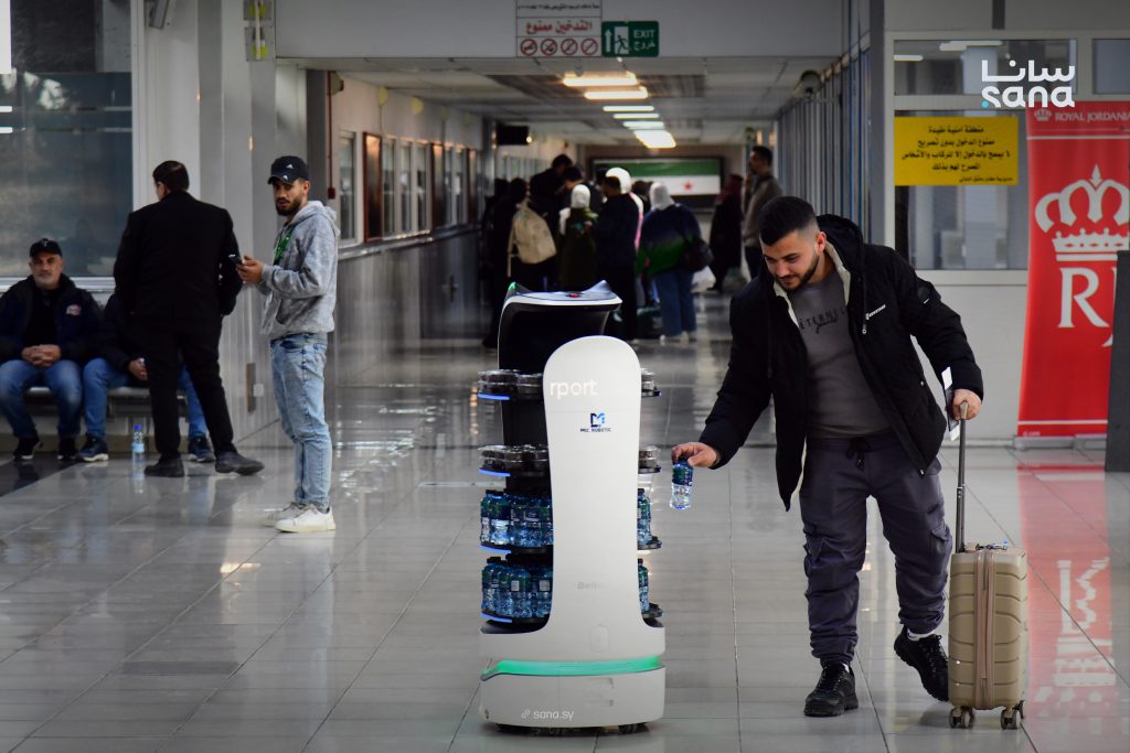 روبوت ذكي يقدّم المياه والتمور للمسافرين في مطار دمشق الدولي