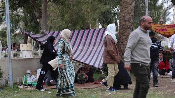 بالكاب والملايات، احتماء زوار الحديقة الدولية من الأمطار بثاني أيام العيد (فيديو وصور)