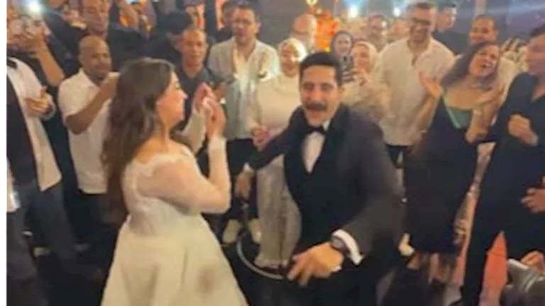 مصطفى منصور يحمل زوجته هايدي رفعت أثناء الرقص في حفل الزفاف